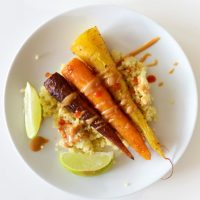 Plate of quinoa topped with Curry Roasted Carrots and Peanut Sauce