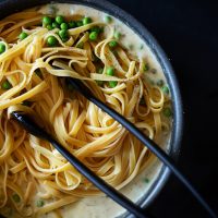Noodles added to a pan to make Butter-less Alfredo with Peas