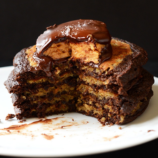 Stack of Chocolate Peanut Butter Cup Pancakes topped with a peanut butter cup