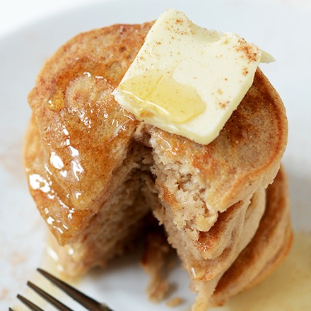 Stack of mini egg-free Sopapilla Pancakes topped with butter and honey