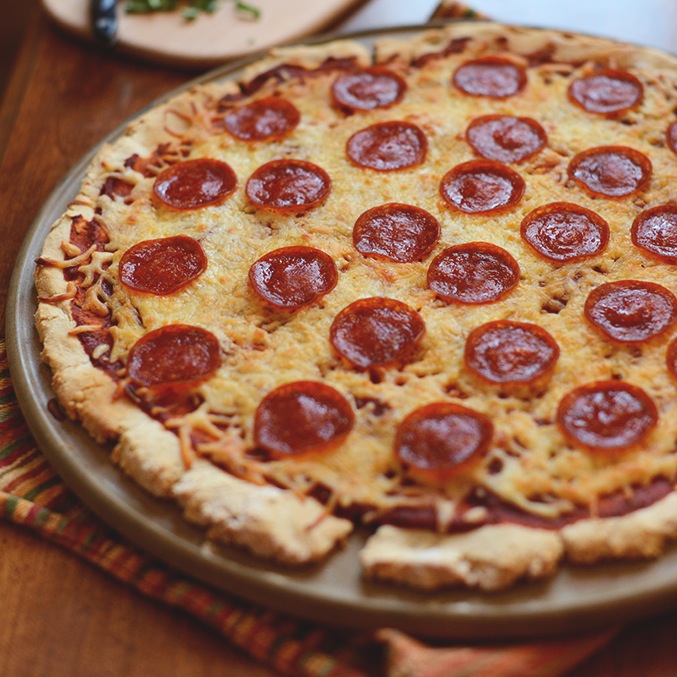 A whole homemade Gluten-Free Pepperoni Pizza on a big plate