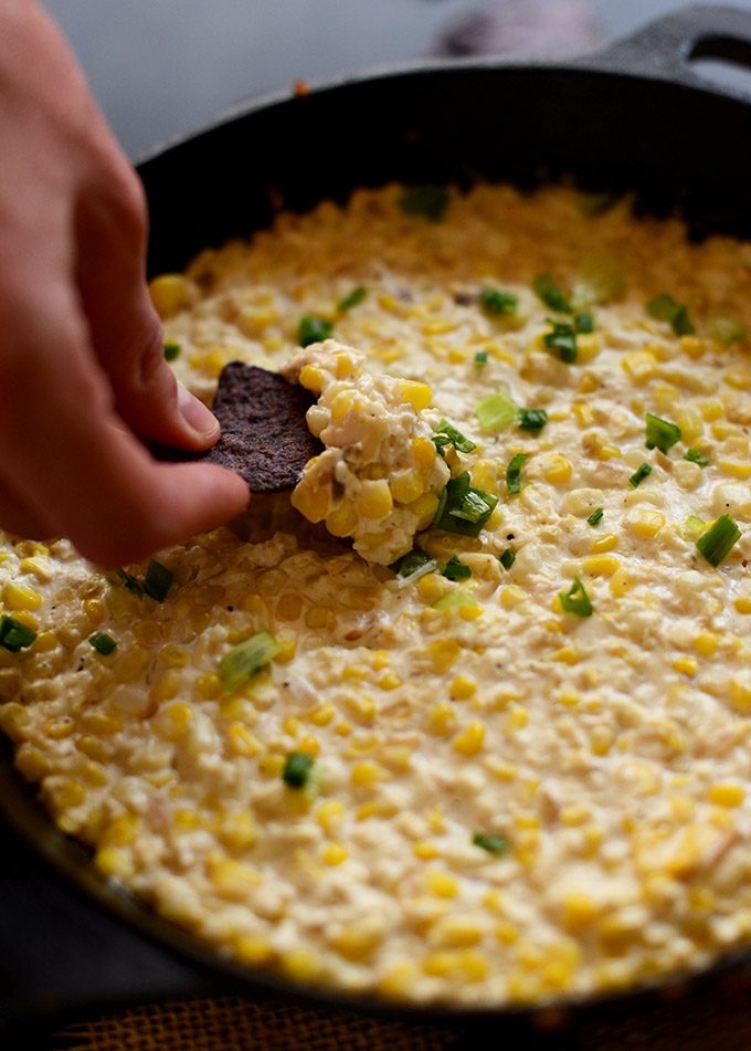 Grabbing a scoop of Corn and Cotija Cheese Dip on a chip
