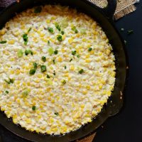Skillet of Summer Corn and Cotija Cheese Dip topped with green onion