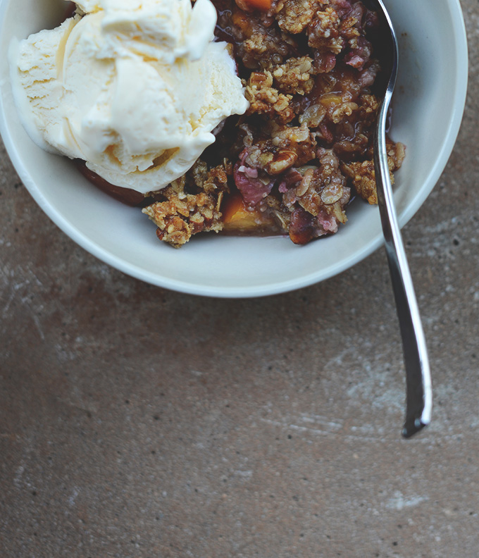Bowl of Gluten-Free Strawberry Crisp with a scoop of ice cream