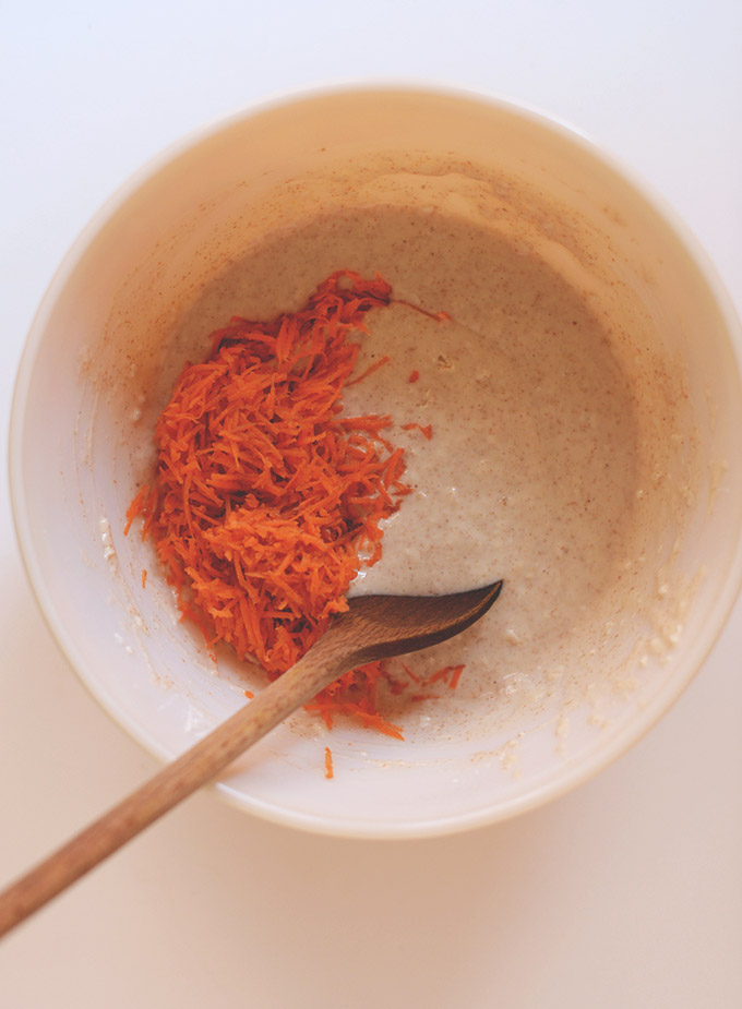 Mixing carrots into a bowl of vegan pancake batter