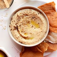Pita chips beside a bowl of homemade Garam Masala Hummus
