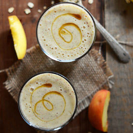 Top down shot of two glasses filled with our Peach Oat Smoothie recipe