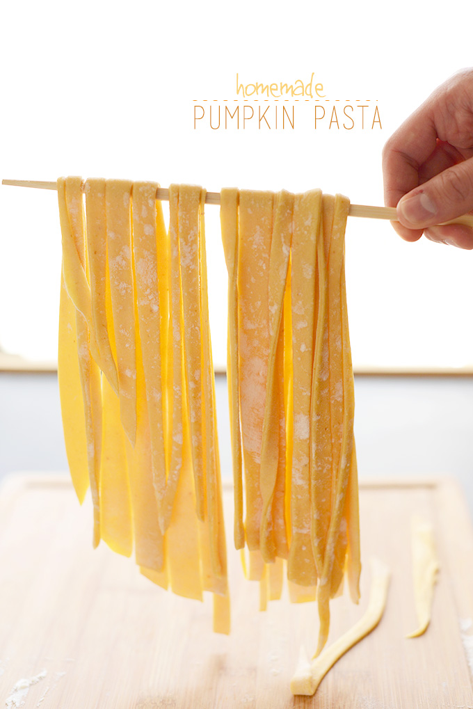 Holding up strands of Homemade Pumpkin Pasta for our Thanksgiving recipe roundup