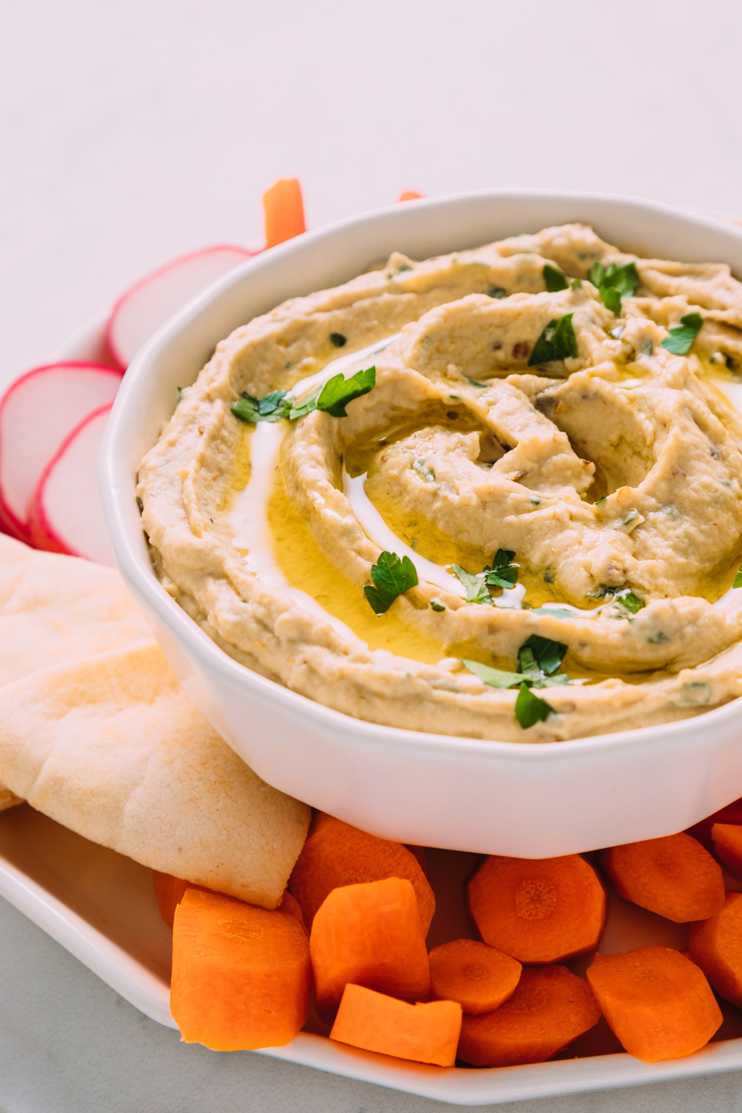 Large bowl of homemade Baba Ganoush beside pita bread and vegetables for a delicious and simple appetizer