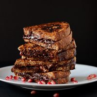 Stack of Grilled Almond Butter, Dark, Chocolate, & Pomegranate sandwiches on a plate