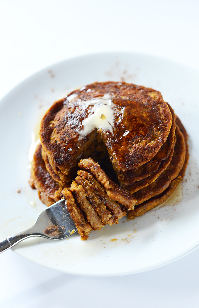 Fork with a bite of Vegan Pumpkin Pancakes alongside the rest of the stack