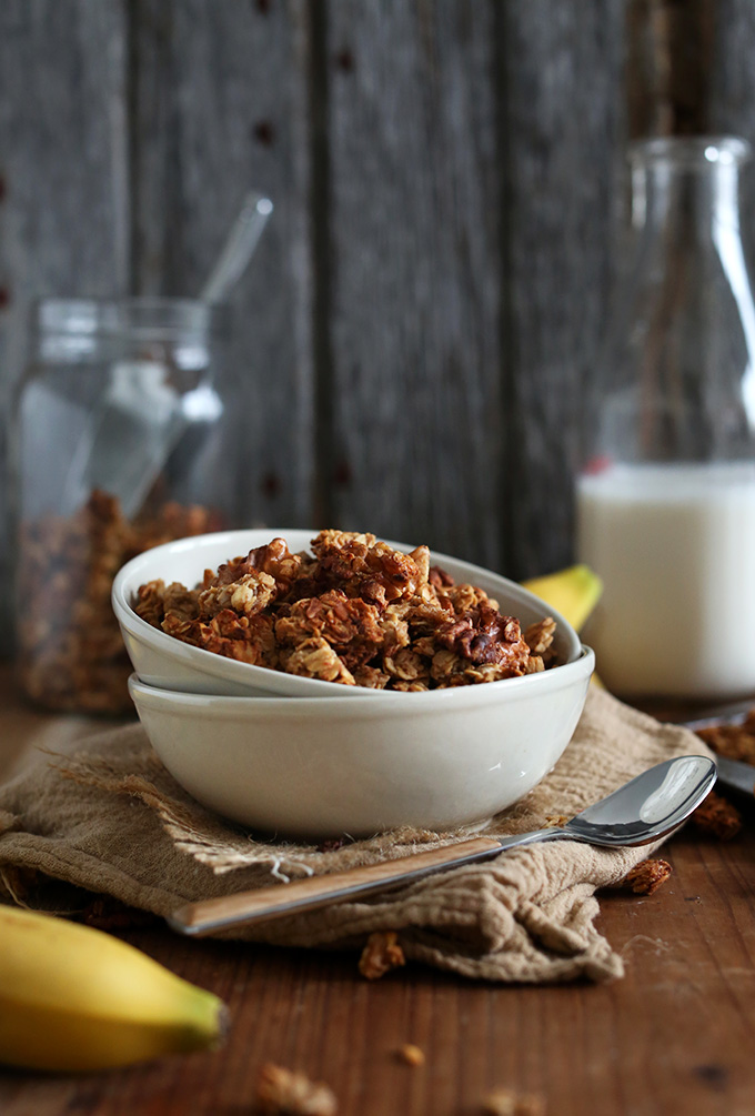 Bowl filled with Banana Bread Granola and jug of almond milk