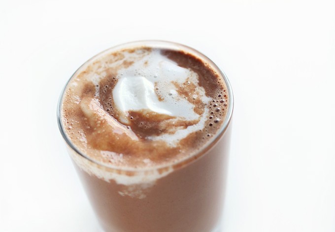 Glass of Easy Vegan Hot Cocoa topped with coconut whipped cream