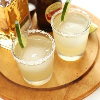 Two homemade Ginger Beer Margaritas on a cutting board