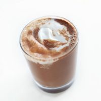 Small glass of Vegan Hot Chocolate topped with coconut whipped cream
