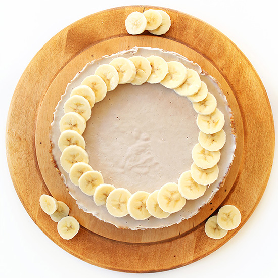 Vegan Gluten-Free Banana Cream Pie on a cutting board with fresh banana slices