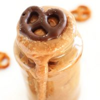 Jar of Chocolate-Covered Pretzel Peanut Butter topped with a chocolate-covered pretzel