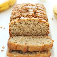 Plate with a partially sliced loaf of Gluten-Free Banana Bread