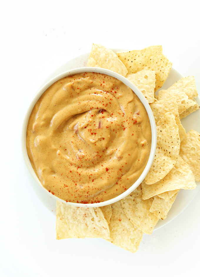 Bowl of soy-free Vegan Queso Dip surrounded by tortilla chips