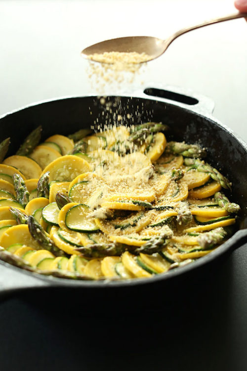 Adding a sprinkling of Vegan Parmesan Cheese to our Asparagus Zucchini Gratin recipe