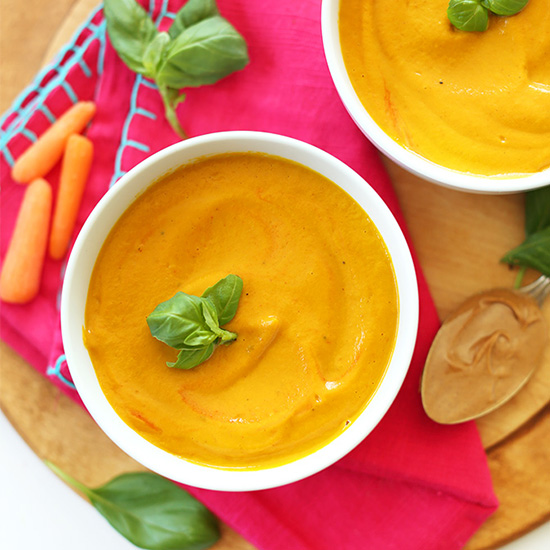 Bowls of Creamy Carrot Soup topped with fresh basil
