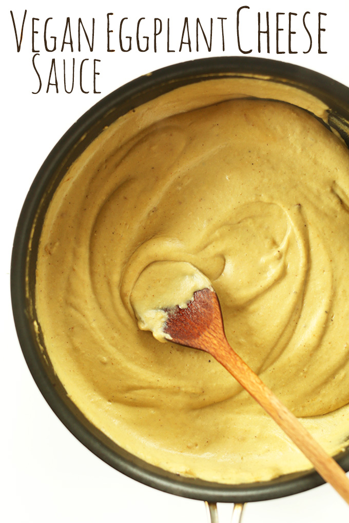 Using a wooden spoon to stir a batch of Vegan Eggplant Cheese Sauce