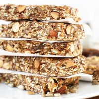 Tall stack of Super Seedy Granola Bars separated by pieces of parchment paper