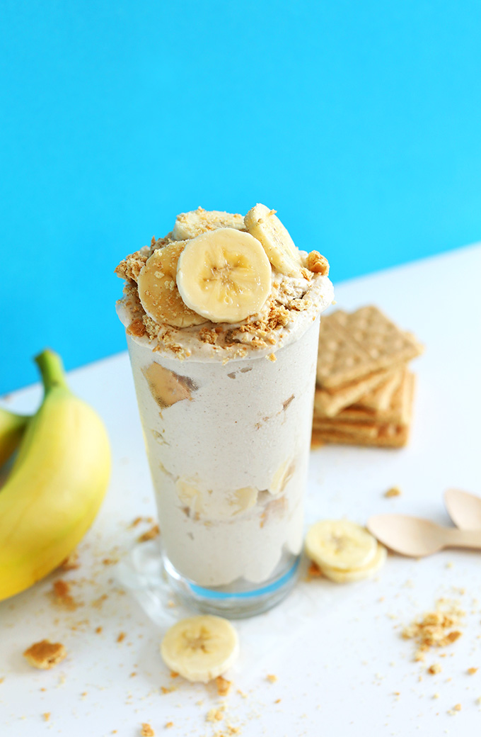 Homemade Banana Cream Pie Blizzards in a glass jar topped with crushed graham cracker and banana