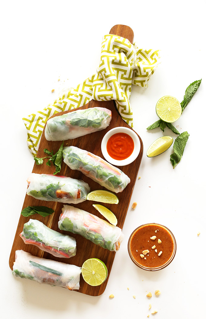 Cutting board with a batch of Vegan Vietnamese Spring Rolls with almond butter dipping sauce