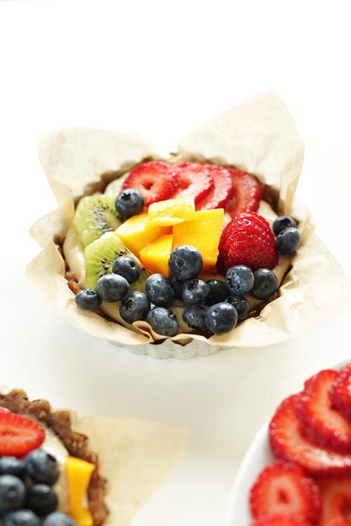 One of our No Bake Lemon Cookie Fruit Tarts in a parchment-lined mini tart pan
