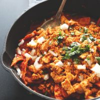 Pan of Vegan Tofu Chilaquiles topped with fresh cilantro and onion