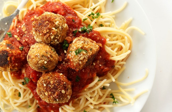 Our 10-Ingredient Vegan Meatballs recipe atop a bed of pasta and marinara sauce