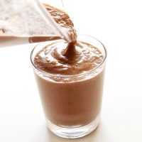 Pouring a glass of our Chocolate Chia Recovery Drink recipe from a blender