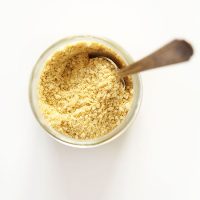 Spoon sticking up from a jar of our homemade Vegan Parmesan Cheese