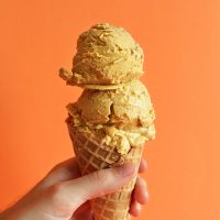 Holding up a waffle cone with two scoops of homemade Pumpkin Pie Ice Cream