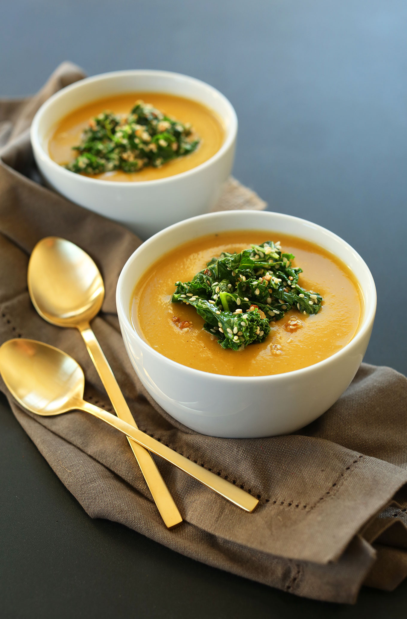 Two bowls of simple vegan Pumpkin Soup with Sesame Kale Topping