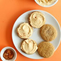 Plate of five Vegan Pumpkin Sugar Cookies with two unfrosted