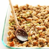 Wooden spoon in a glass baking dish filled with our Easy Vegan Stuffing recipe