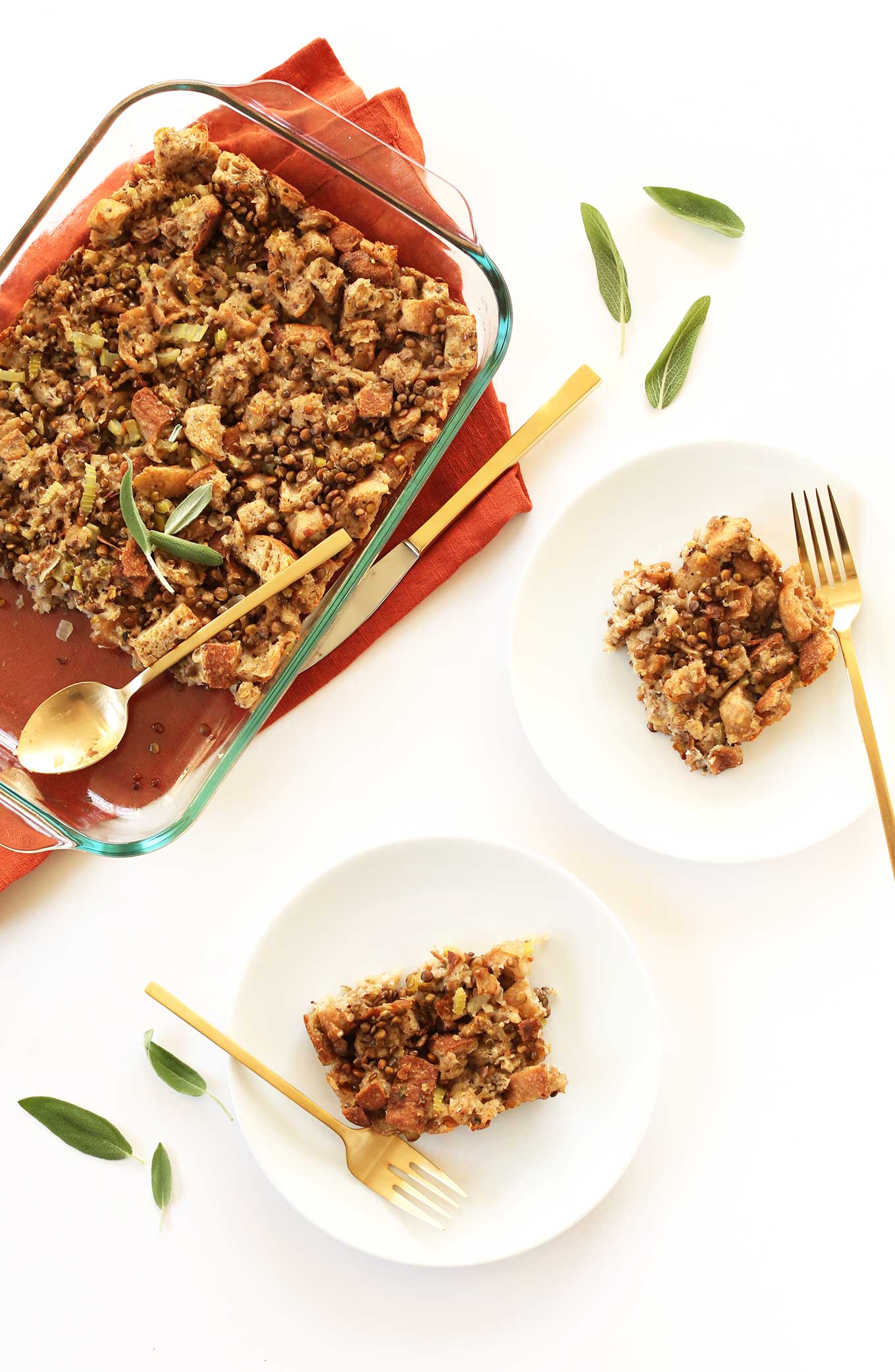 Two plates and a baking dish filled with hearty vegan stuffing