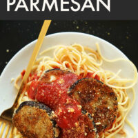 Plate of vegan eggplant parmesan over spaghetti noodles