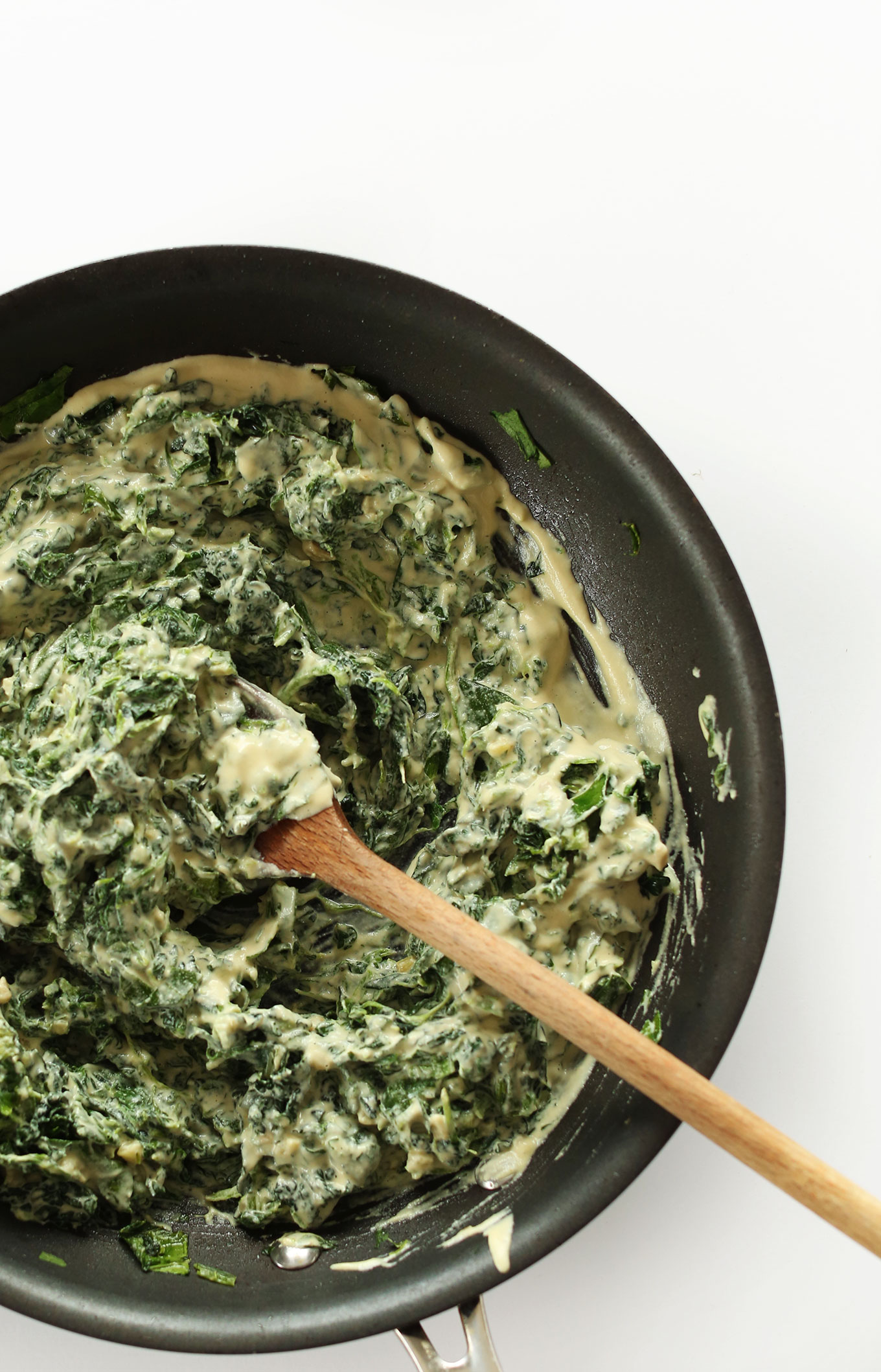 Stirring together our vegan Kale and Spinach Dip recipe in a skillet