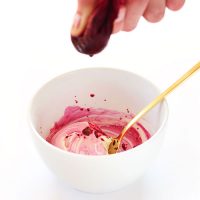 Squeezing beet juice into a bowl to make DIY Natural Food Dye