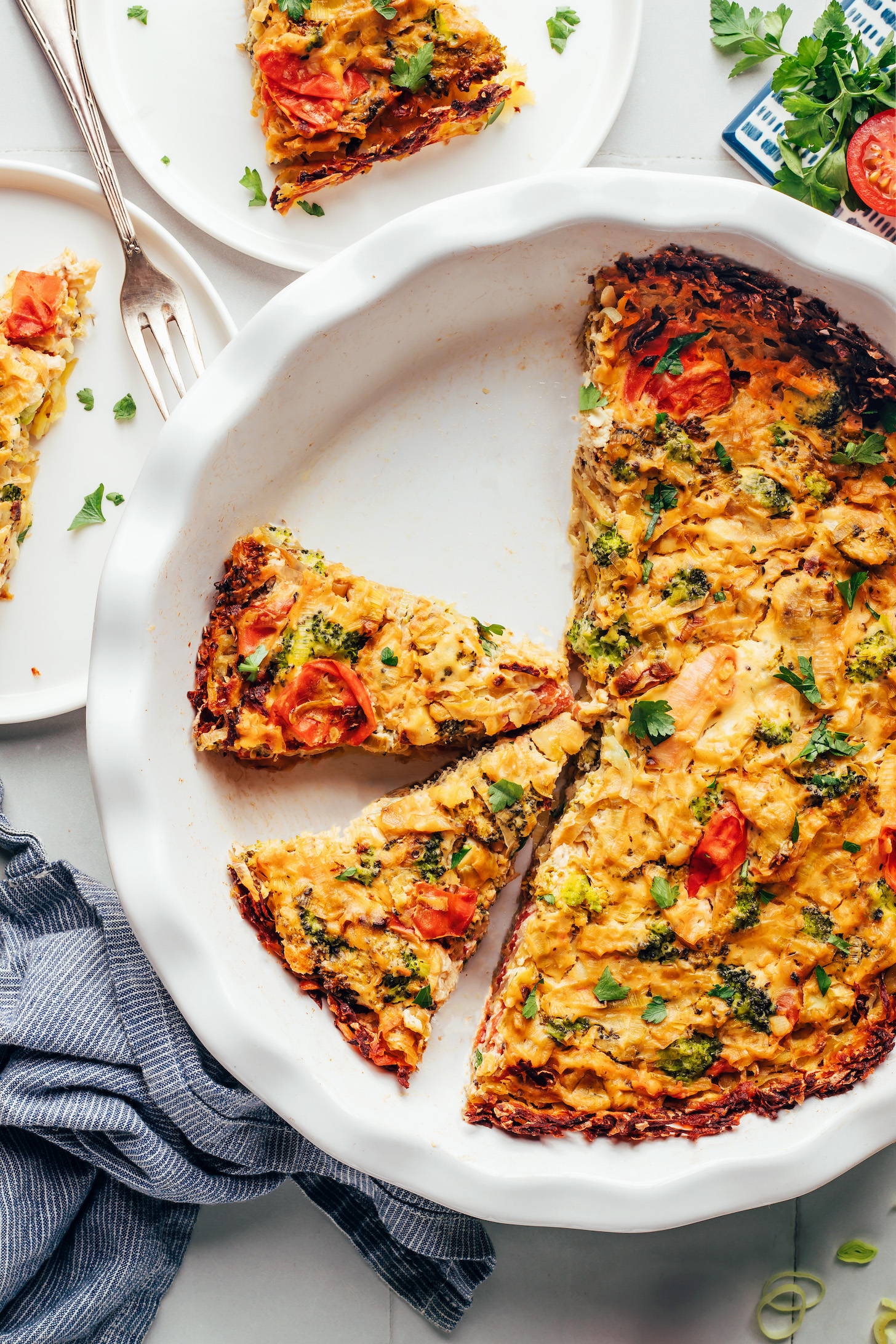 Partially sliced gluten-free vegan Tofu Quiche made with roasted veggies