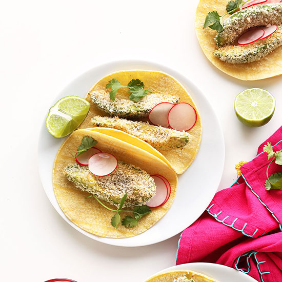 Platse of Panko Baked Avocado Tacos with sliced radishes, limes, and cilantro