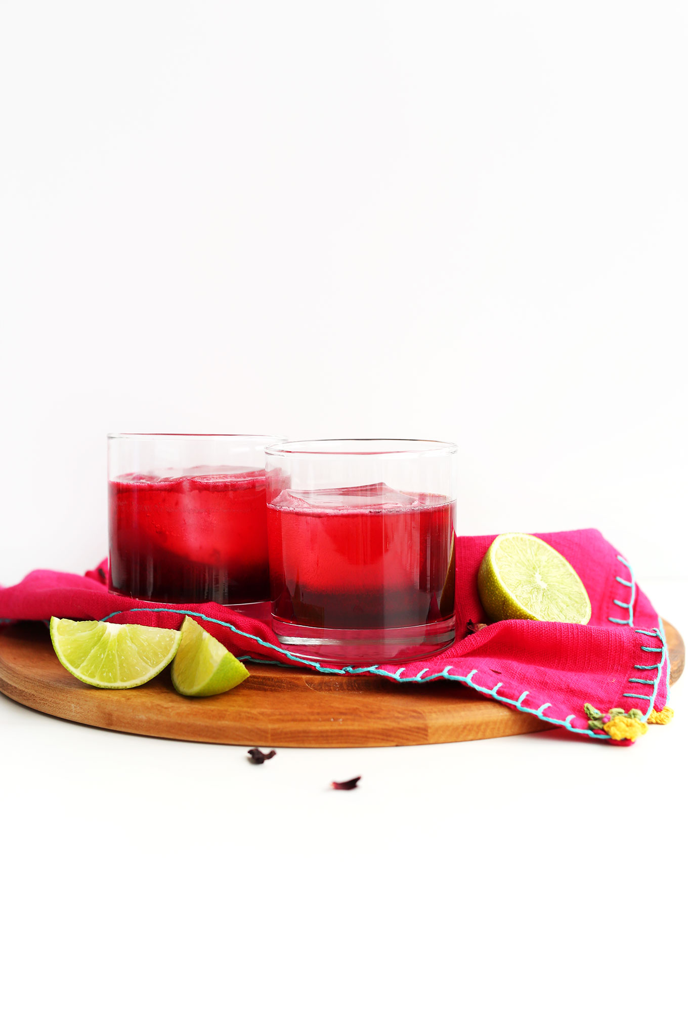 Two glasses of our Hibiscus Margarita recipe with limes