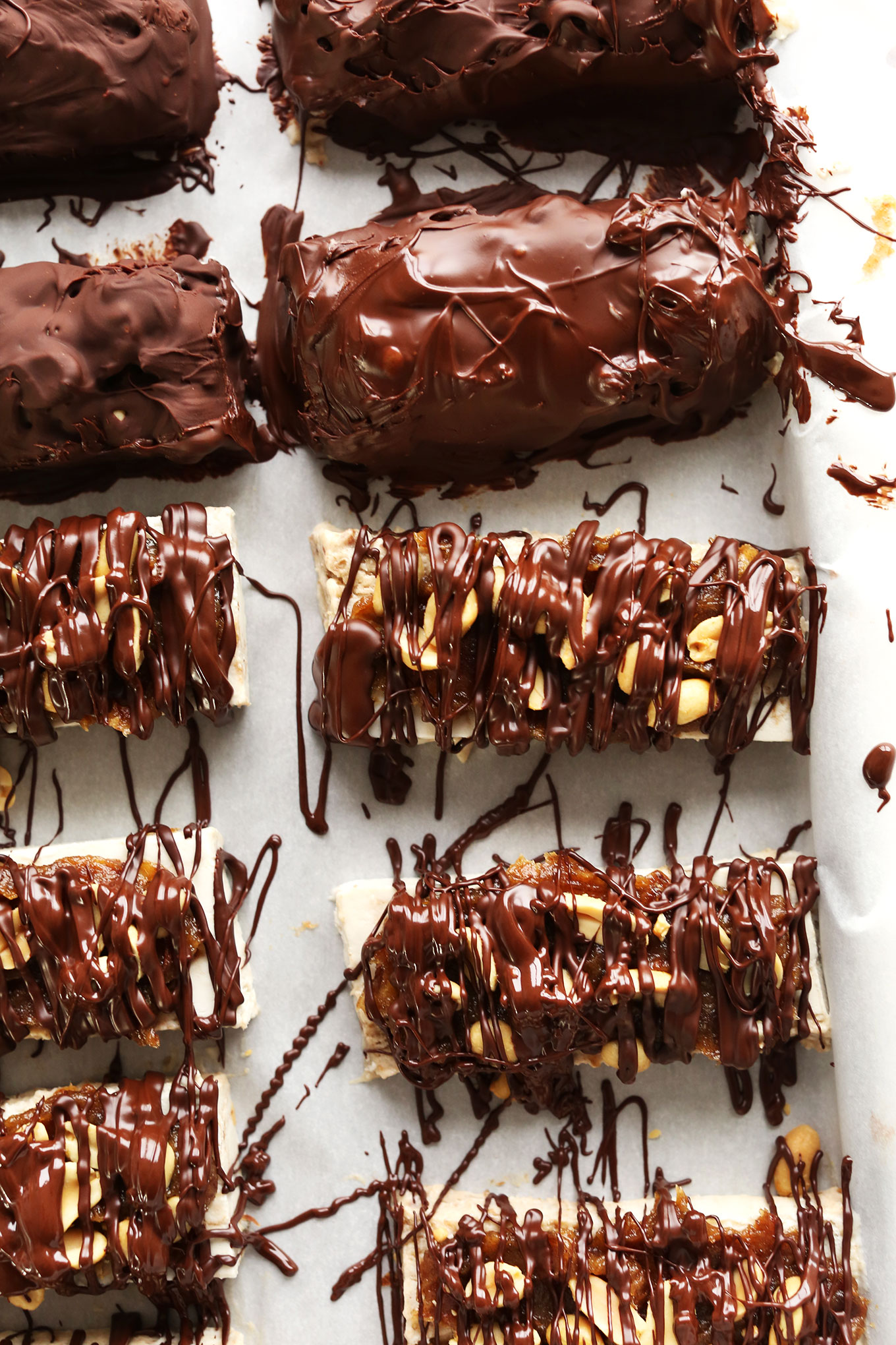 Parchment-lined baking sheet with delicious gluten-free Vegan Ice Cream Snickers Bars