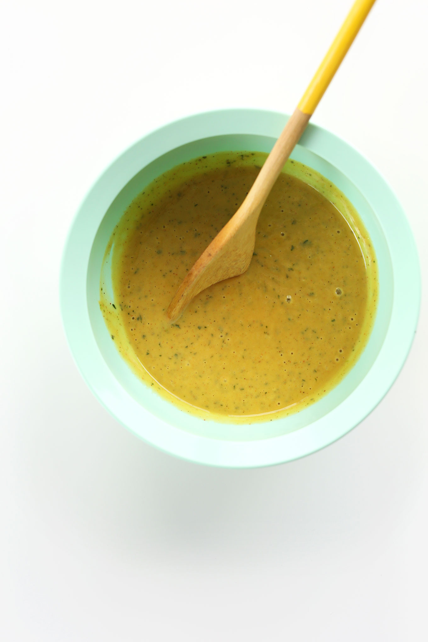 Bowl of Creamy Orange Chili Cilantro Dressing for drizzling on a delicious vegan dinner salad