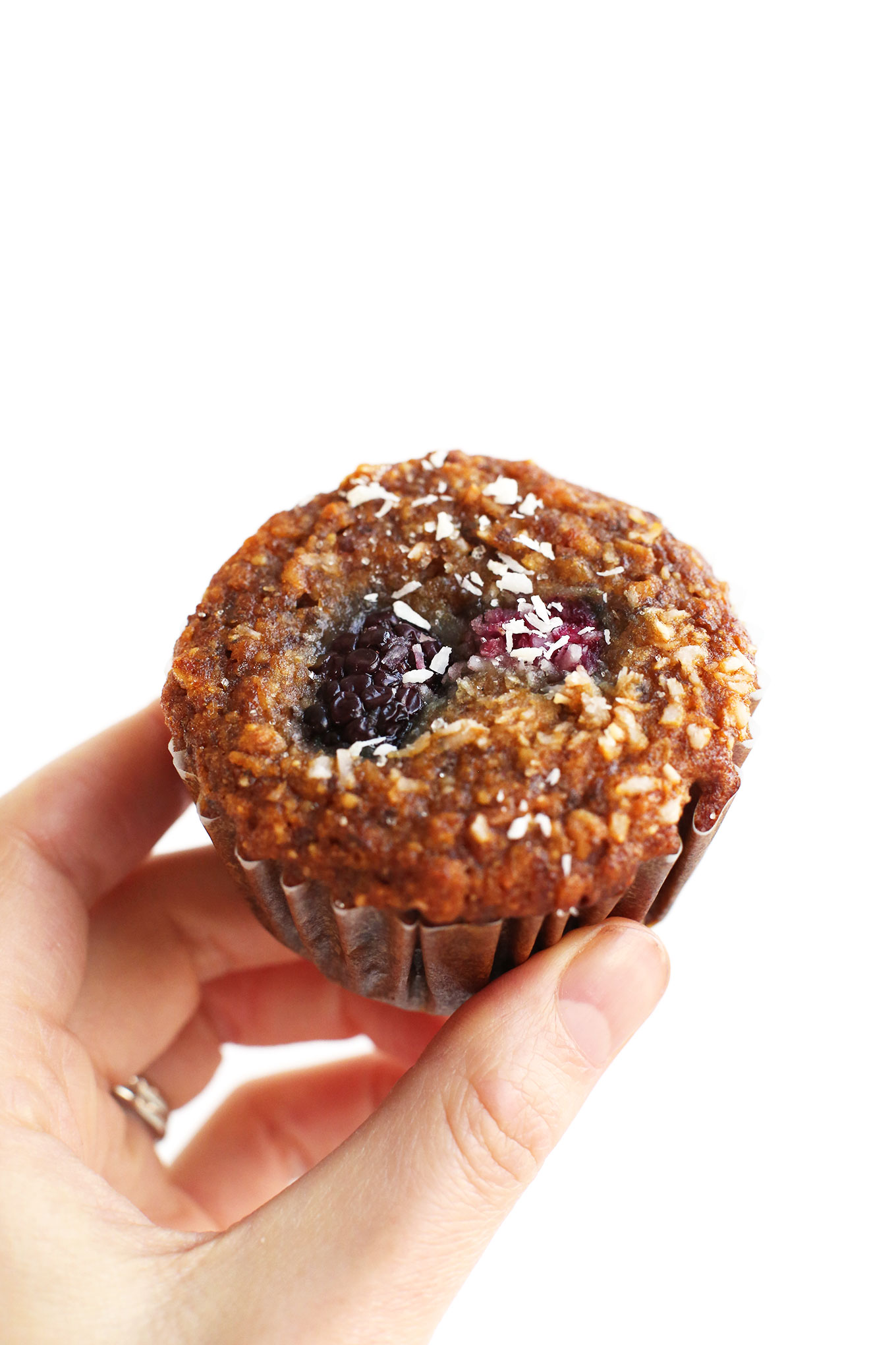 Holding up a Berry Coconut Muffin for a healthy gluten-free vegan snack