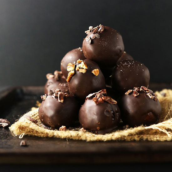 Stack of Healthy Vegan Chocolate Truffles topped with cacao nibs