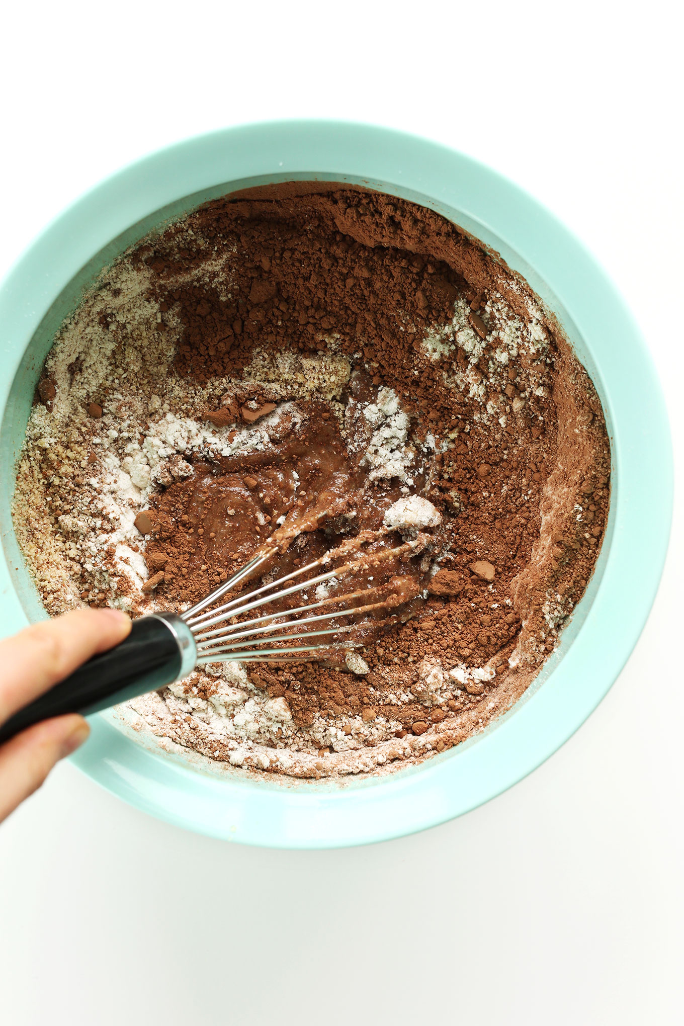 Mixing wet and dry ingredients for our easy Vegan Gluten-Free Chocolate Hazelnut Cake Recipe